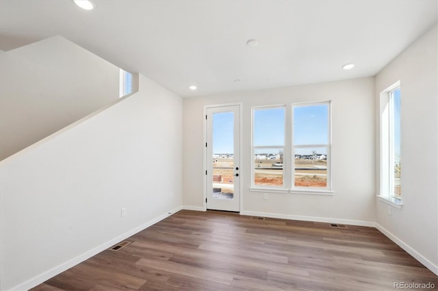 unfurnished room featuring wood-type flooring and a wealth of natural light