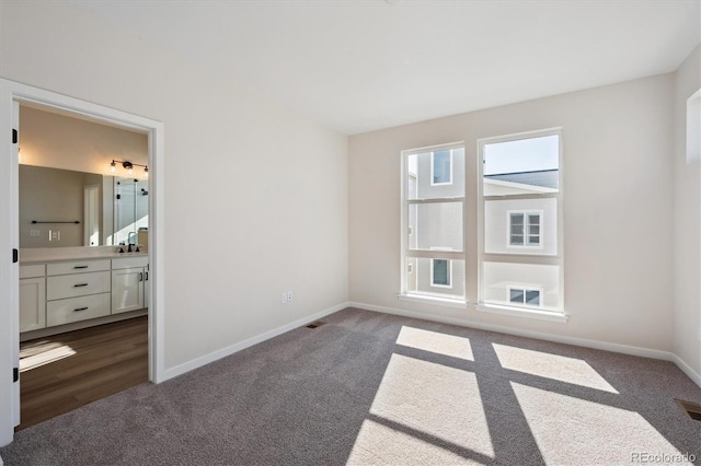 spare room featuring dark colored carpet