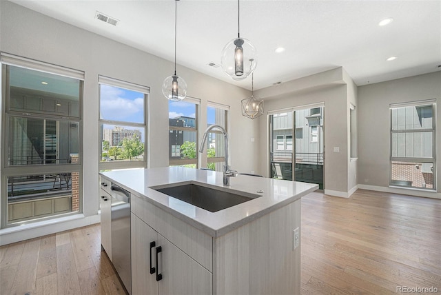 5018 S Prince Pl, Littleton, CO 80123 - kitchen with dishwasher, light wood-style floors, a kitchen island with sink, recessed lighting, and pendant lighting