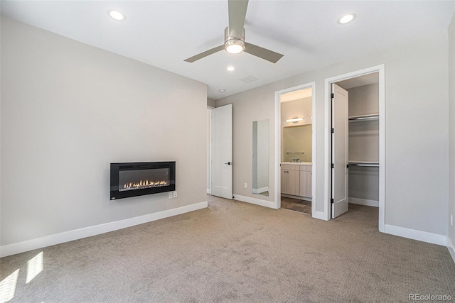 5018 S Prince Pl, Littleton, CO 80123 - unfurnished bedroom with carpet, a glass covered fireplace, a walk in closet, recessed lighting, and connected bathroom