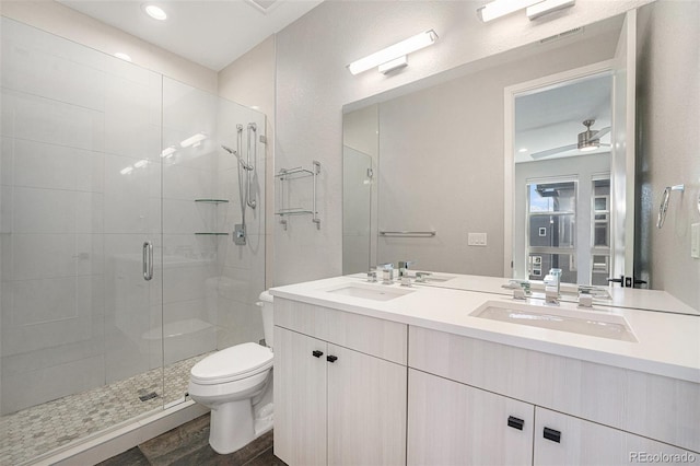 5018 S Prince Pl, Littleton, CO 80123 - full bathroom with double vanity, a shower stall, wood finished floors, ceiling fan, and recessed lighting