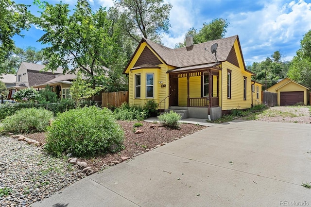1318 S 25th St, Colorado Springs, CO 80904 - victorian house featuring a chimney, roof with shingles, covered porch, driveway, and a detached garage