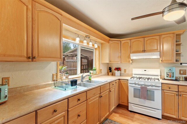1318 S 25th St, Colorado Springs, CO 80904 - kitchen featuring white range with gas cooktop, under cabinet range hood, light brown cabinetry, and light countertops