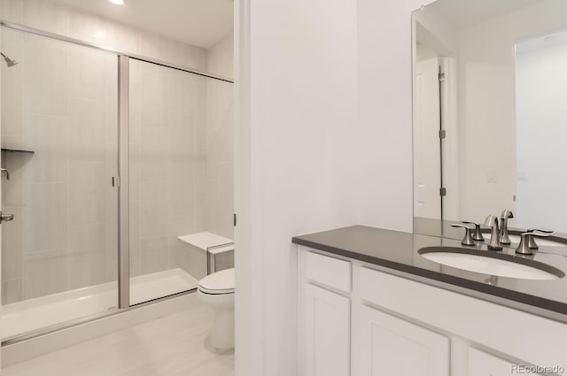 bathroom featuring vanity, toilet, and walk in shower