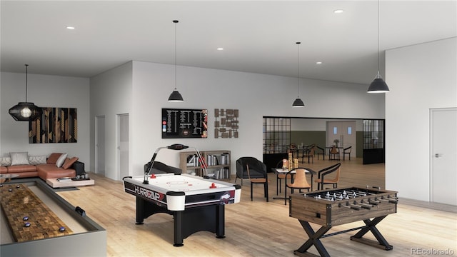 recreation room with a towering ceiling and light wood-type flooring