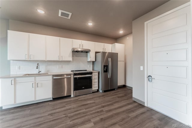 kitchen with sink, light hardwood / wood-style flooring, white cabinets, stainless steel appliances, and backsplash