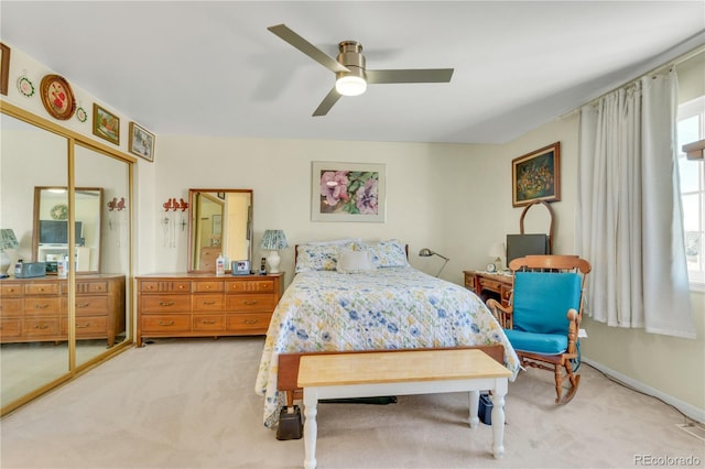 bedroom with light colored carpet, ceiling fan, and a closet