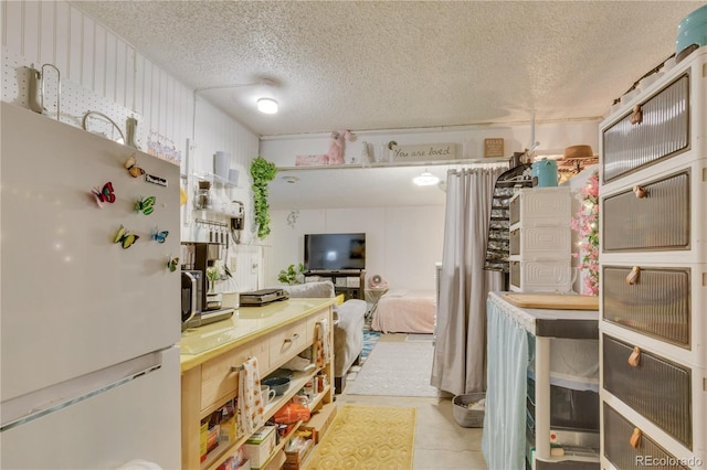 kitchen featuring white fridge and a textured ceiling