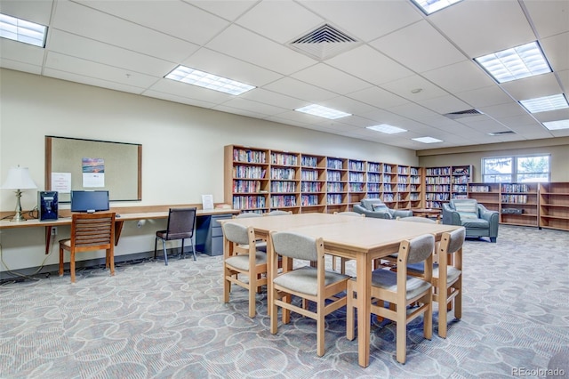 dining area featuring light colored carpet and a drop ceiling