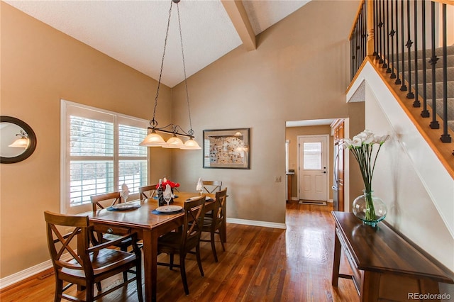 dining space featuring high vaulted ceiling, dark wood-type flooring, stairway, and baseboards