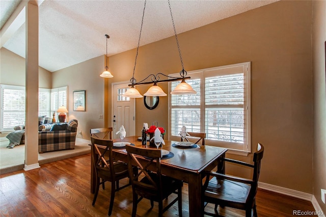 dining area featuring a wealth of natural light, vaulted ceiling, and dark wood-type flooring