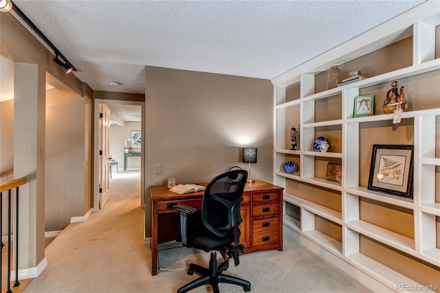 office space with a textured ceiling, baseboards, and carpet flooring