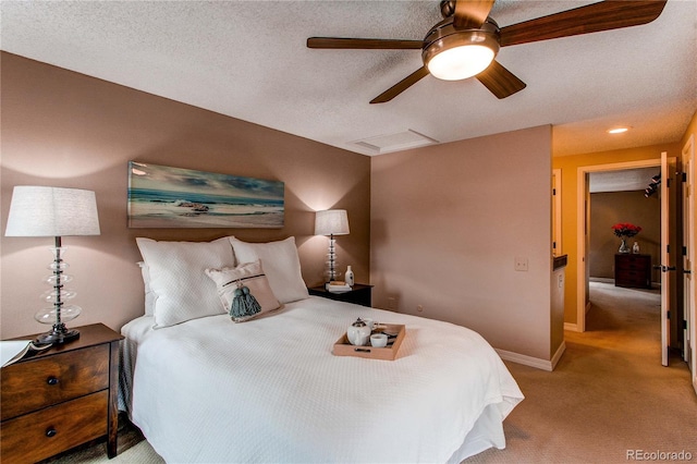 bedroom with a textured ceiling, light carpet, visible vents, baseboards, and attic access