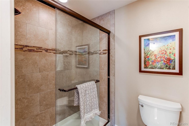 bathroom featuring a shower stall and toilet