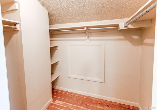 walk in closet with wood finished floors