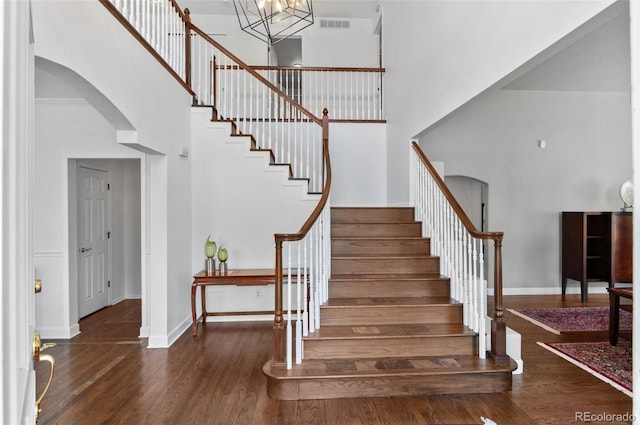 2032 W Nantucket Ct, Littleton, CO 80120 - stairs featuring a high ceiling, arched walkways, wood finished floors, and baseboards