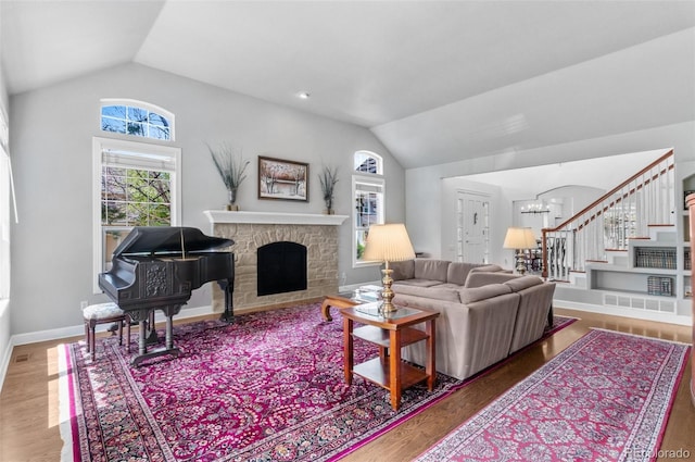 2032 W Nantucket Ct, Littleton, CO 80120 - living room with lofted ceiling, stairs, a chandelier, wood finished floors, and a fireplace