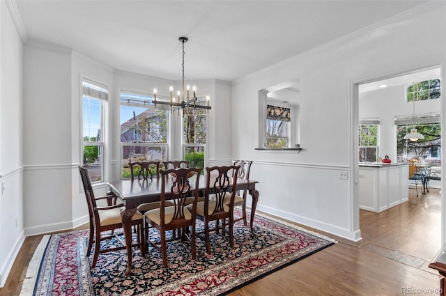 2032 W Nantucket Ct, Littleton, CO 80120 - dining space featuring a chandelier, wood finished floors, ornamental molding, and baseboards