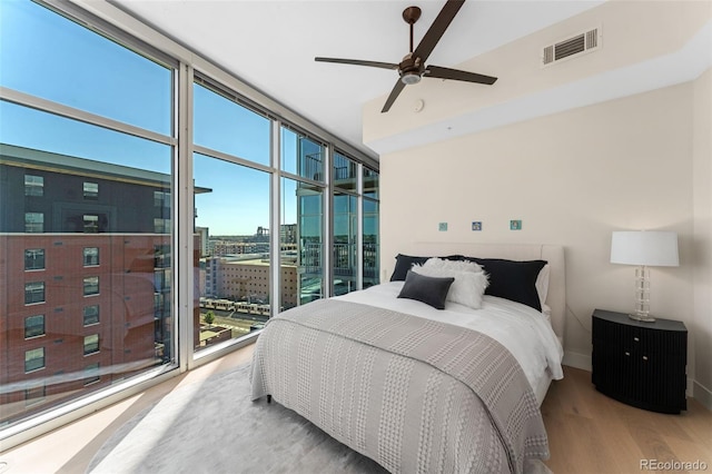 1700 Bassett St Unit 1014, Denver, CO 80202 - bedroom featuring expansive windows, wood finished floors, a view of city, a ceiling fan, and access to exterior