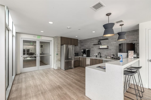 1700 Bassett St Unit 1014, Denver, CO 80202 - kitchen featuring stainless steel appliances, modern cabinets, a peninsula, light countertops, and a kitchen breakfast bar