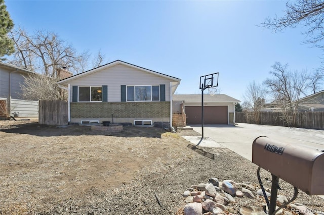 view of front of home featuring an outbuilding, fence, an attached garage, concrete driveway, and brick siding