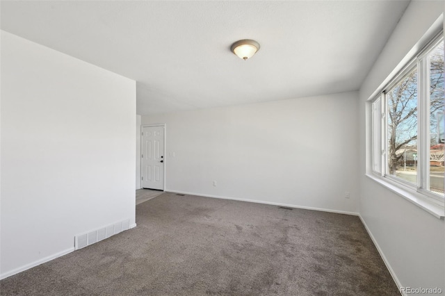 empty room featuring visible vents, baseboards, and carpet