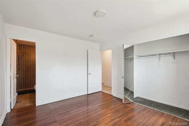 unfurnished bedroom featuring dark wood finished floors, baseboards, and a closet