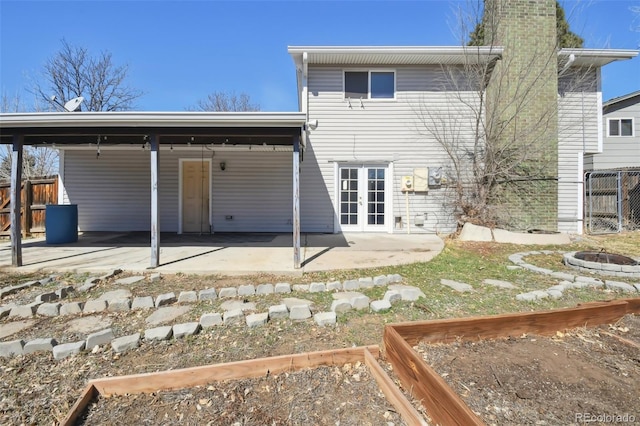 rear view of property featuring a patio, french doors, and fence