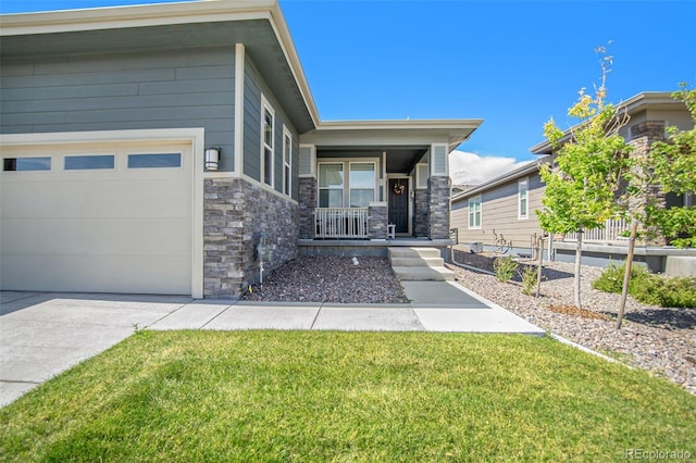 view of front of house featuring a porch, driveway, stone siding, and a front lawn