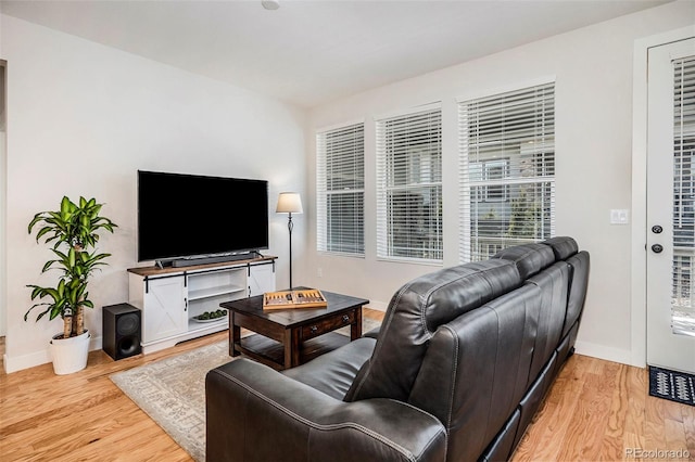 living area with baseboards and light wood finished floors