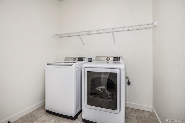 laundry room featuring washer and dryer, light tile patterned floors, laundry area, and baseboards