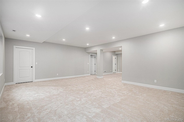 empty room featuring light carpet, baseboards, and recessed lighting