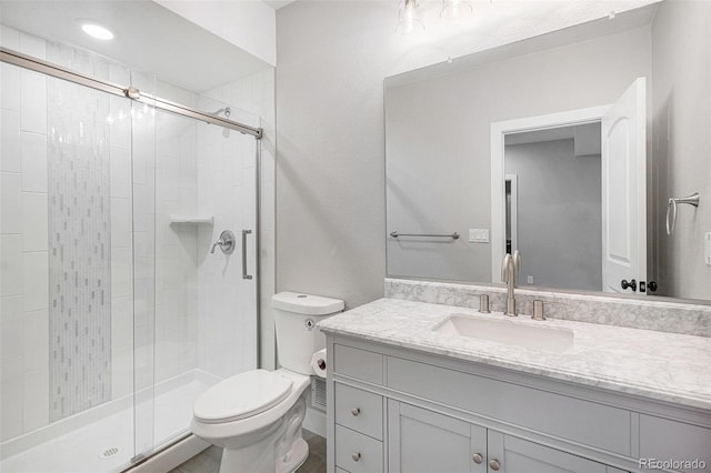 bathroom featuring toilet, a stall shower, and vanity