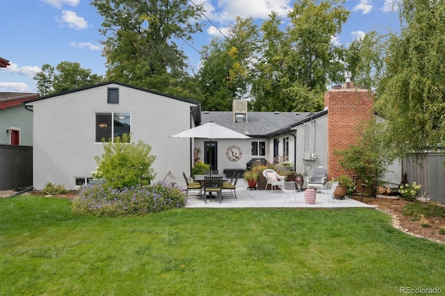 back of property featuring a yard and a patio