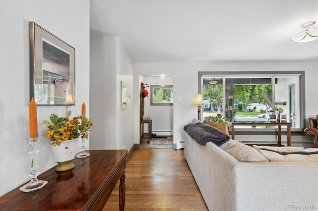 living room with wood-type flooring and a baseboard heating unit