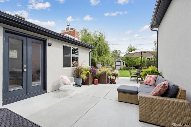 view of patio featuring french doors, outdoor lounge area, and a shed