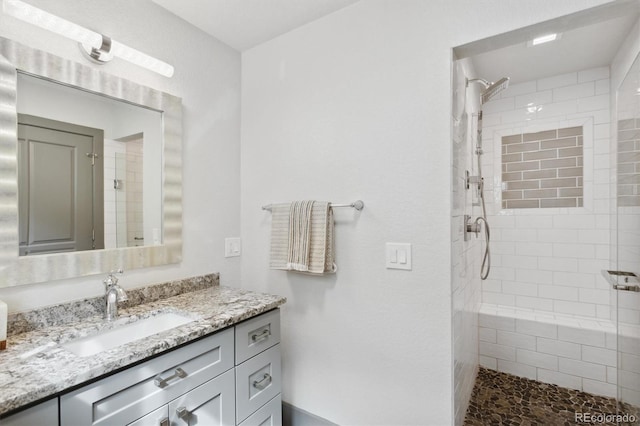 bathroom featuring vanity and a tile shower