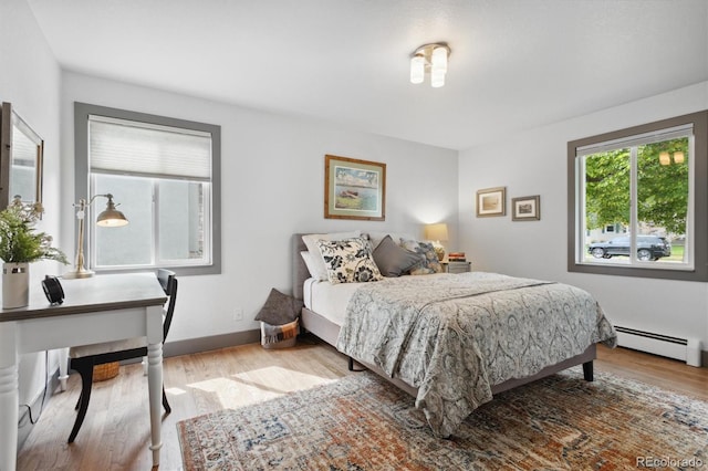 bedroom featuring a baseboard radiator and light hardwood / wood-style flooring