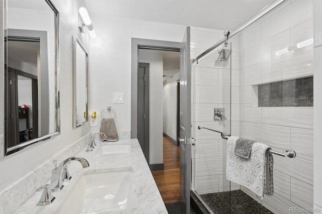 bathroom featuring walk in shower, vanity, and hardwood / wood-style flooring