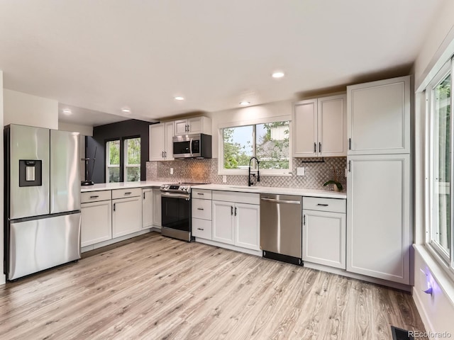 6378 S Emporia Cir, Englewood, CO 80111 - kitchen featuring stainless steel appliances, light countertops, a sink, decorative backsplash, and recessed lighting