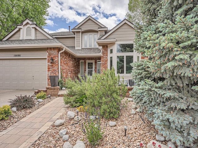19098 E Ida Dr, Aurora, CO 80015 - view of front facade with a shingled roof, brick siding, a garage, and concrete driveway