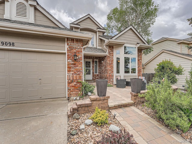 19098 E Ida Dr, Aurora, CO 80015 - view of front facade featuring brick siding, driveway, a shingled roof, and a garage