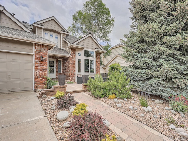 19098 E Ida Dr, Aurora, CO 80015 - view of front of house with brick siding, a shingled roof, concrete driveway, and a garage