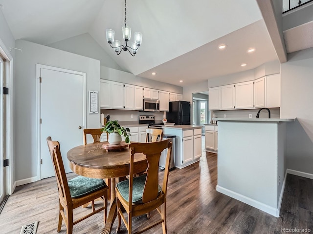 19098 E Ida Dr, Aurora, CO 80015 - dining room with a chandelier, vaulted ceiling, wood finished floors, recessed lighting, and baseboards