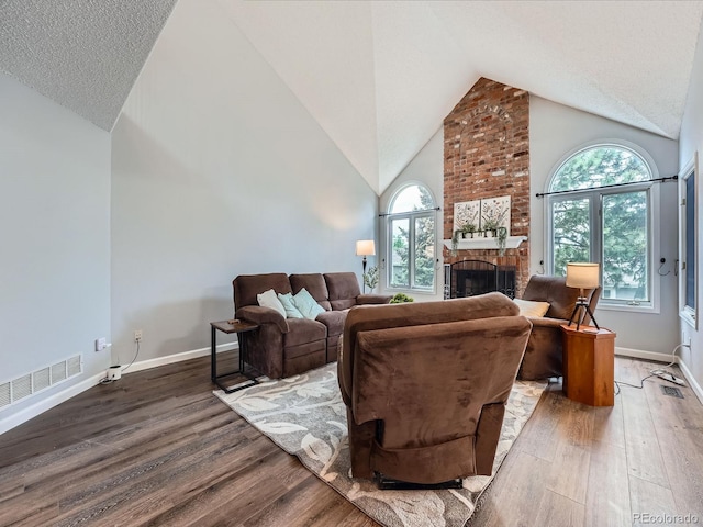 19098 E Ida Dr, Aurora, CO 80015 - living area featuring wood finished floors, a brick fireplace, high vaulted ceiling, baseboards, and a textured ceiling