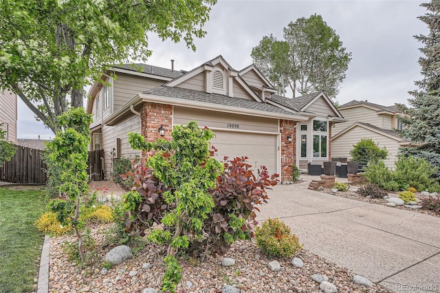 19098 E Ida Dr, Aurora, CO 80015 - view of front of home with an attached garage, brick siding, concrete driveway, and roof with shingles