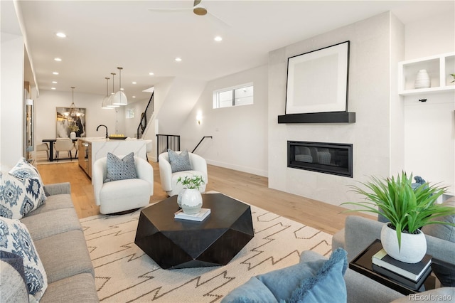 2060 Eliot St, Denver, CO 80211 - living area featuring light wood-type flooring, recessed lighting, a tiled fireplace, a chandelier, and stairs