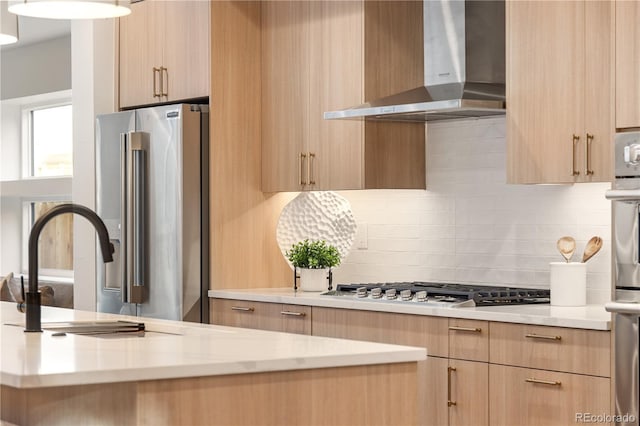 2060 Eliot St, Denver, CO 80211 - kitchen with wall chimney exhaust hood, stainless steel appliances, light brown cabinetry, and decorative backsplash