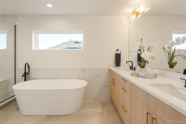 2060 Eliot St, Denver, CO 80211 - bathroom featuring a freestanding bath, double vanity, tile walls, a wainscoted wall, and a shower