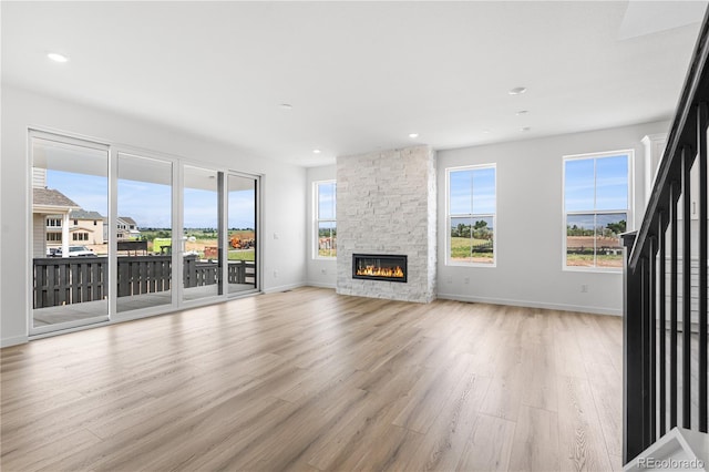 8863 Springsong Ln, Littleton, CO 80125 - unfurnished living room featuring light wood-style floors, a fireplace, and recessed lighting